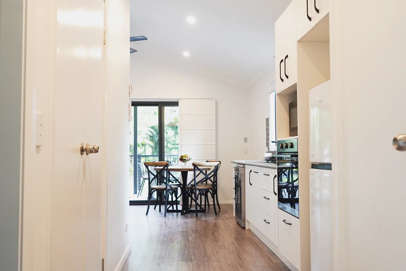 Wide, step-free hallway in the accessible cabin, looking past the doorway through to the dining table and kitchen.